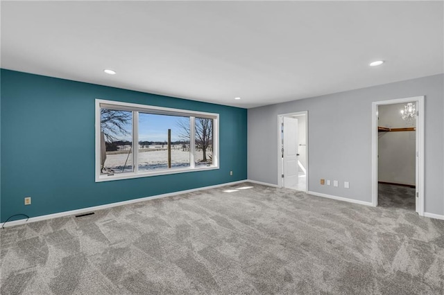 unfurnished bedroom featuring recessed lighting, visible vents, a spacious closet, light carpet, and baseboards