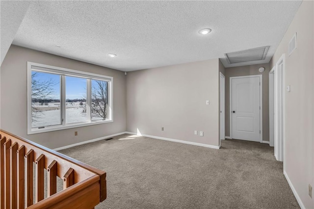 empty room featuring carpet floors, visible vents, and baseboards