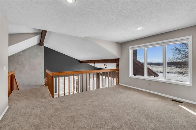 additional living space featuring vaulted ceiling with beams, carpet, visible vents, and baseboards