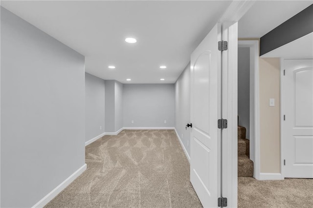 finished below grade area featuring recessed lighting, stairs, baseboards, and light colored carpet