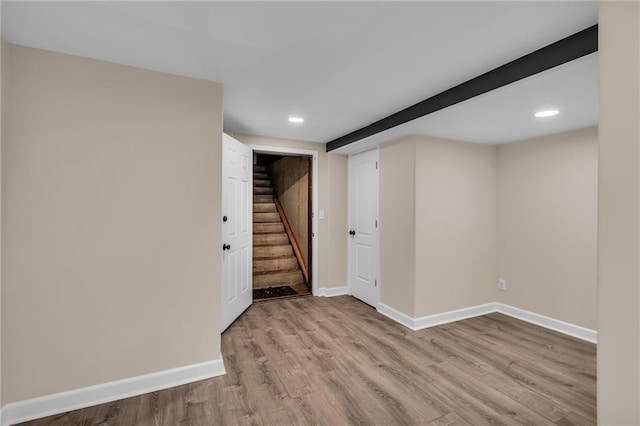 finished basement with light wood finished floors, stairway, recessed lighting, and baseboards