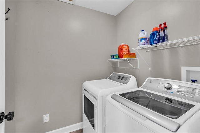 washroom with laundry area, baseboards, and separate washer and dryer