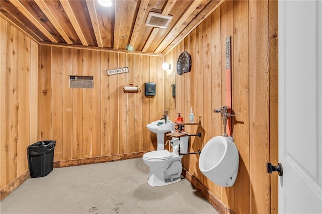 bathroom with toilet, wood walls, concrete floors, and wooden ceiling