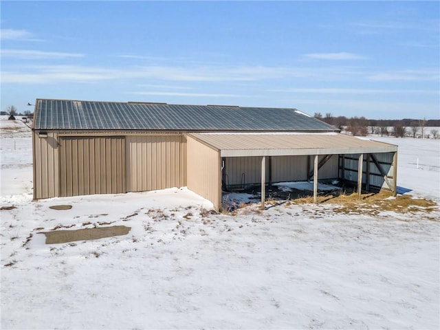 snow covered garage featuring a garage and a carport