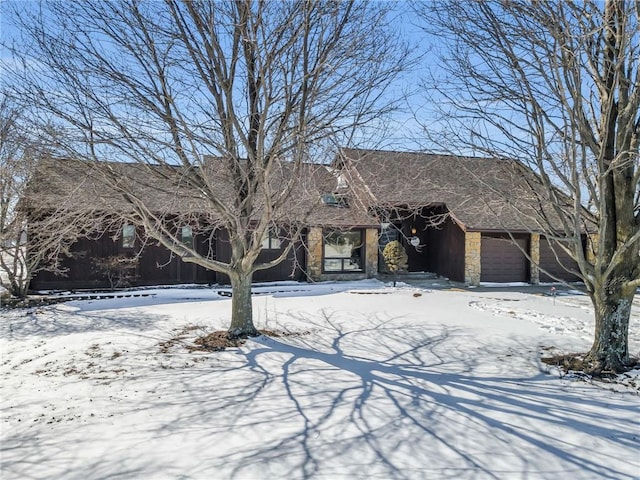 view of front of property featuring a garage and stone siding