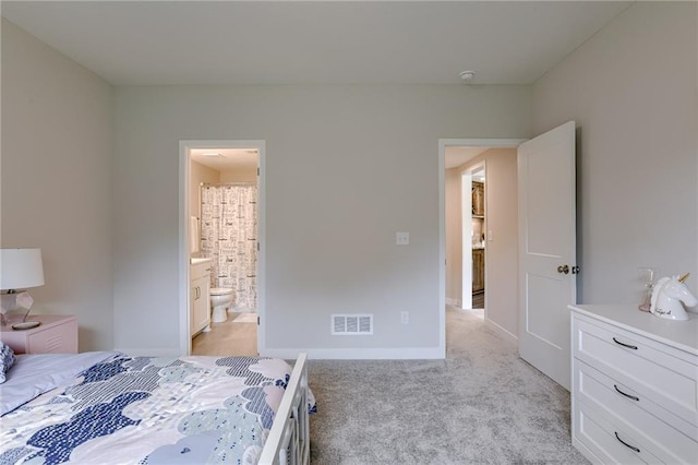 bedroom with light carpet, visible vents, ensuite bath, and baseboards