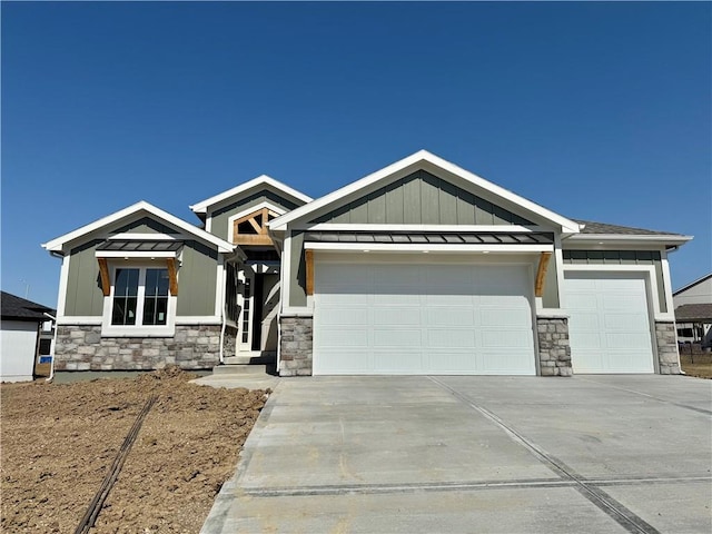 craftsman inspired home with board and batten siding, metal roof, driveway, an attached garage, and a standing seam roof