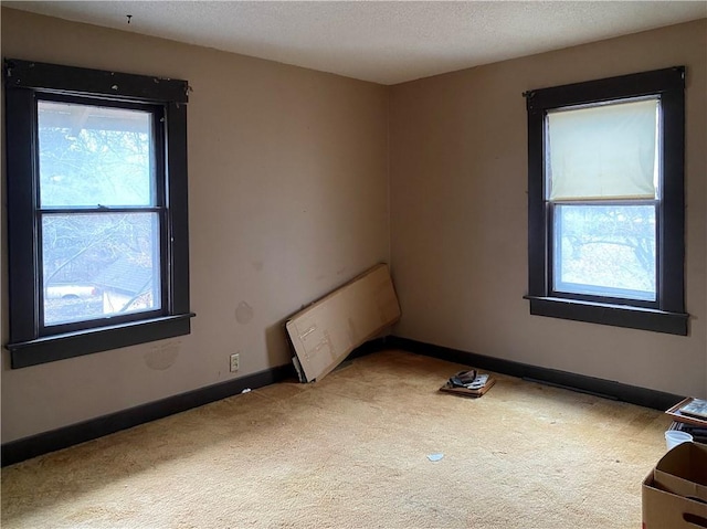 carpeted spare room featuring radiator and a textured ceiling