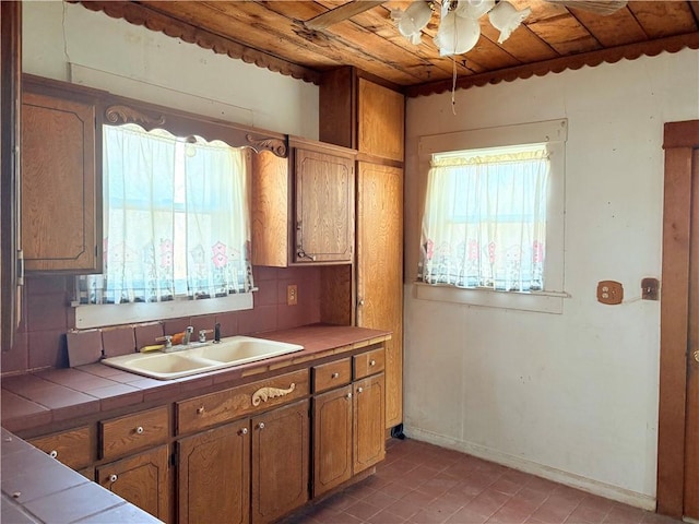 305 E 8th St, Wellsville, KS 66092 - kitchen featuring tile countertops, a ceiling fan, wooden ceiling, a healthy amount of sunlight, and a sink