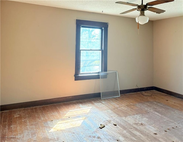 305 E 8th St, Wellsville, KS 66092 - empty room with wood-type flooring, baseboards, a ceiling fan, and a textured ceiling