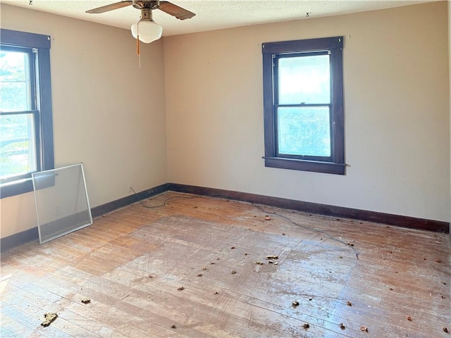 305 E 8th St, Wellsville, KS 66092 - empty room with a wealth of natural light, a ceiling fan, and baseboards