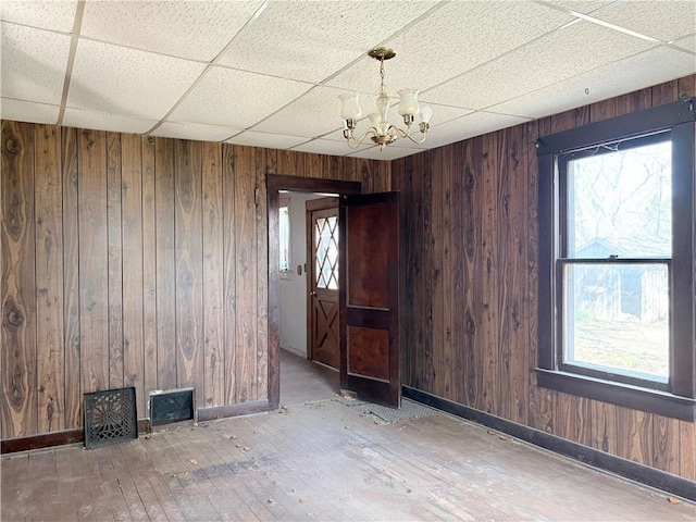 305 E 8th St, Wellsville, KS 66092 - spare room with wood-type flooring, a paneled ceiling, a notable chandelier, and wood walls