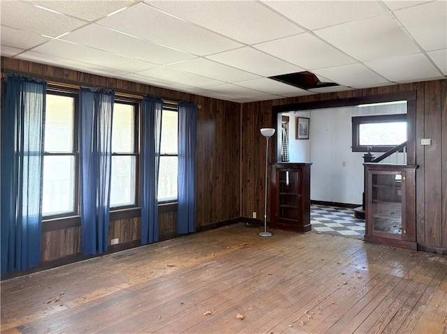 305 E 8th St, Wellsville, KS 66092 - spare room with wood-type flooring, a paneled ceiling, visible vents, and wooden walls