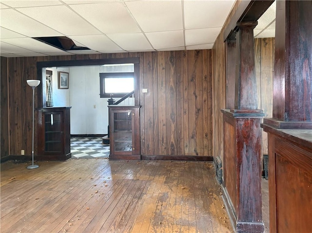305 E 8th St, Wellsville, KS 66092 - bar featuring wood walls, wood-type flooring, a drop ceiling, and baseboards