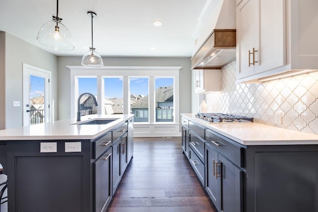 kitchen with pendant lighting, sink, stainless steel appliances, and a center island with sink