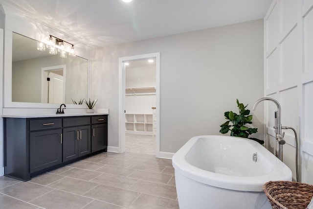 bathroom with vanity, a bath, and tile patterned floors