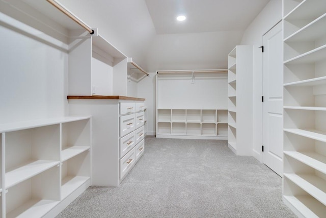 walk in closet featuring light colored carpet