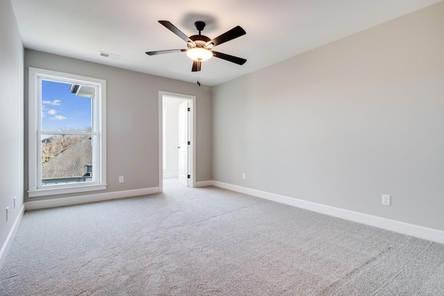 carpeted spare room featuring ceiling fan