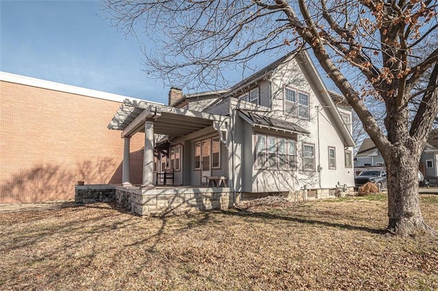 view of side of property featuring a patio and a lawn