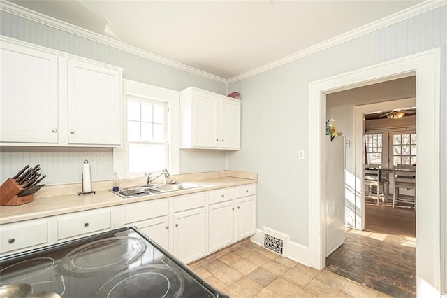 kitchen with white cabinetry, sink, and a healthy amount of sunlight