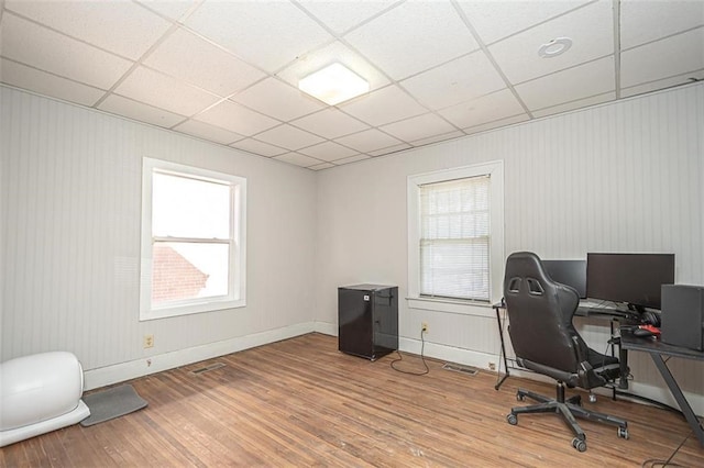 office space featuring wood-type flooring and a paneled ceiling