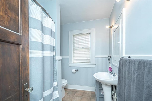 bathroom featuring toilet and a shower with shower curtain