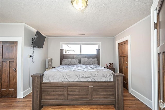 bedroom featuring ornamental molding, dark hardwood / wood-style floors, and a textured ceiling