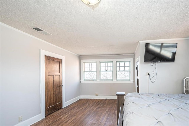 bedroom featuring ornamental molding, dark wood-type flooring, and a textured ceiling