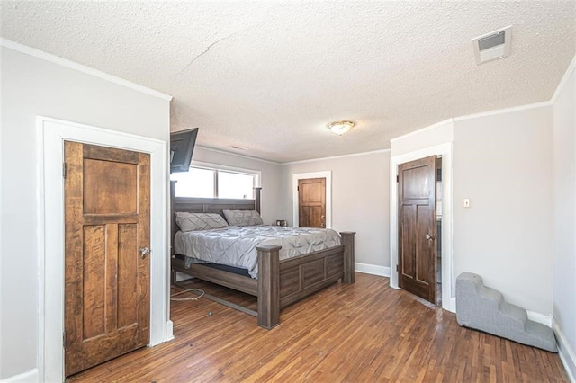 bedroom featuring crown molding, dark hardwood / wood-style flooring, and a textured ceiling