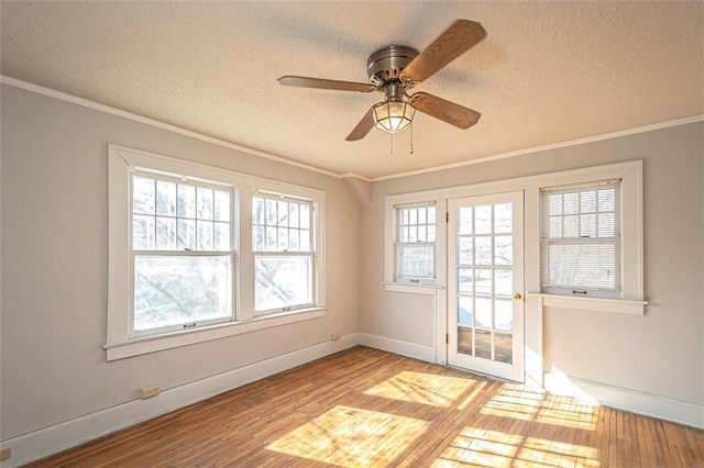 spare room with ceiling fan, ornamental molding, a textured ceiling, and light wood-type flooring