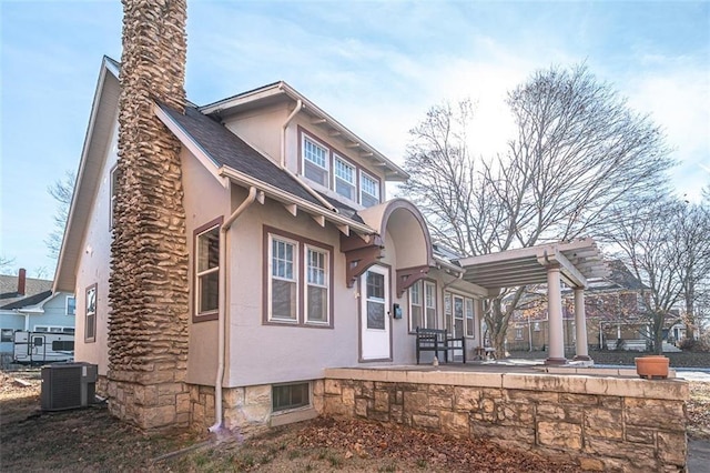 rear view of property featuring cooling unit, a pergola, and a patio