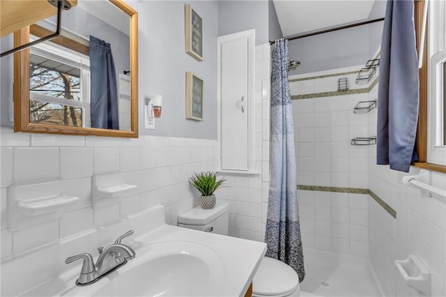 bathroom with tile walls, sink, toilet, and walk in shower