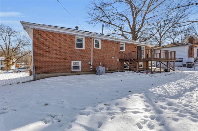 snow covered house featuring a deck