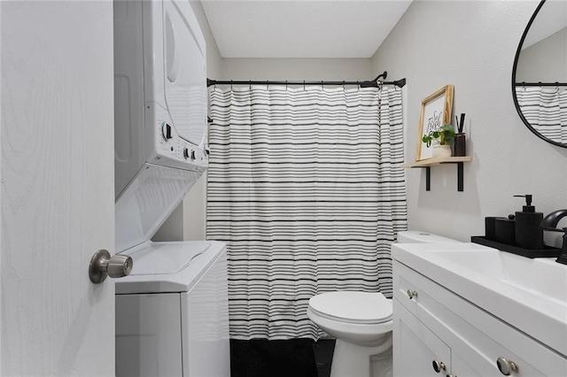 bathroom with a shower with curtain, vanity, stacked washer / drying machine, and toilet