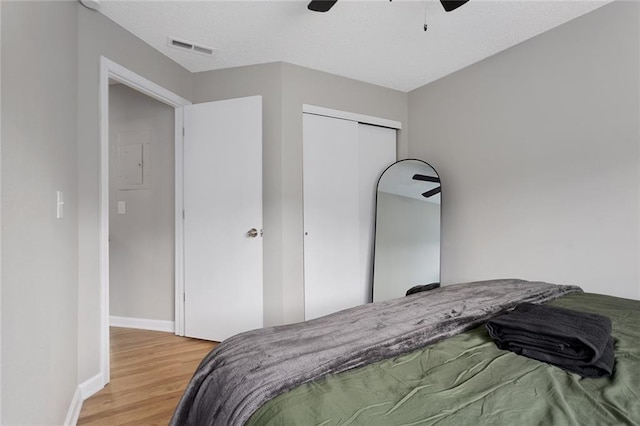 bedroom with wood-type flooring, a closet, and ceiling fan