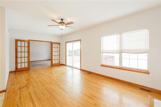 empty room with light hardwood / wood-style flooring, french doors, and ceiling fan