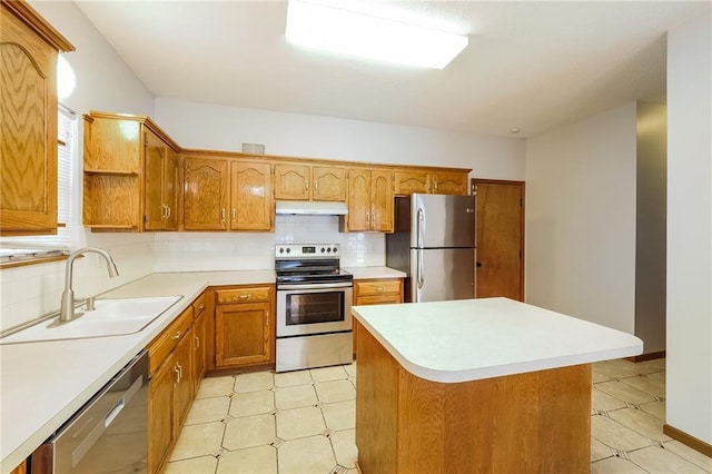 kitchen featuring tasteful backsplash, appliances with stainless steel finishes, sink, and a kitchen island