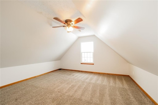 bonus room with vaulted ceiling, ceiling fan, and carpet flooring