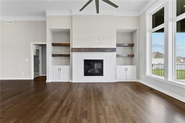 unfurnished living room featuring crown molding, ceiling fan, dark hardwood / wood-style floors, and built in shelves