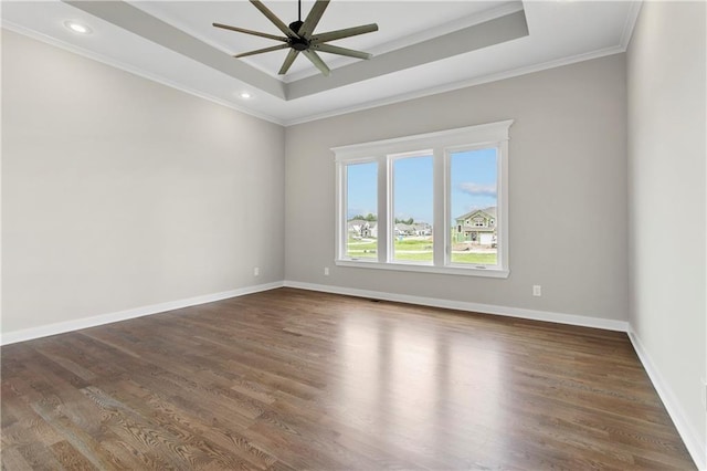 spare room featuring ornamental molding, dark hardwood / wood-style floors, ceiling fan, and a tray ceiling