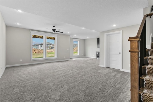 unfurnished living room featuring carpet and ceiling fan