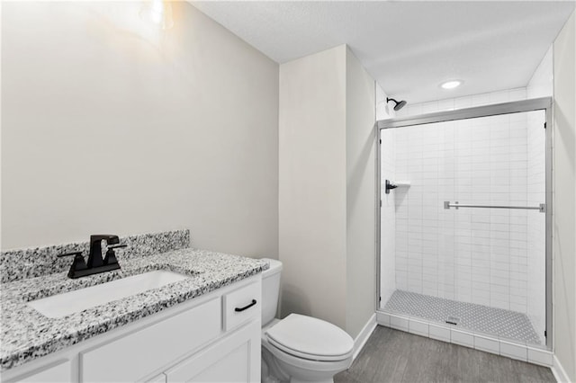 bathroom with vanity, hardwood / wood-style floors, toilet, and walk in shower