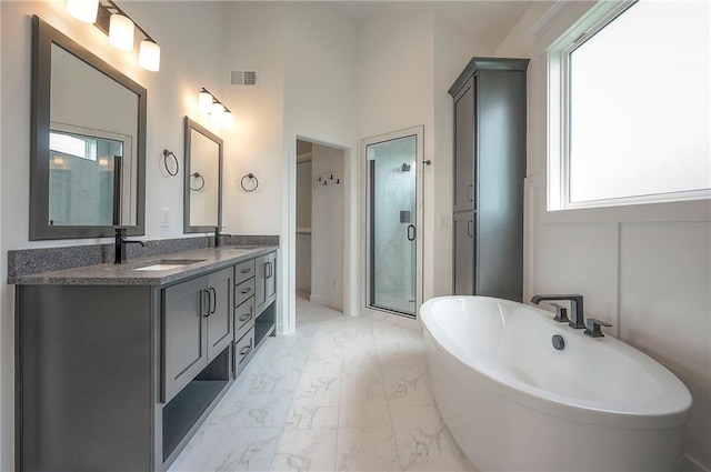 9000 N Clarion Ave, Kansas City, MO 64153 - bathroom featuring marble look tiles, a freestanding bath, double vanity, and a shower stall