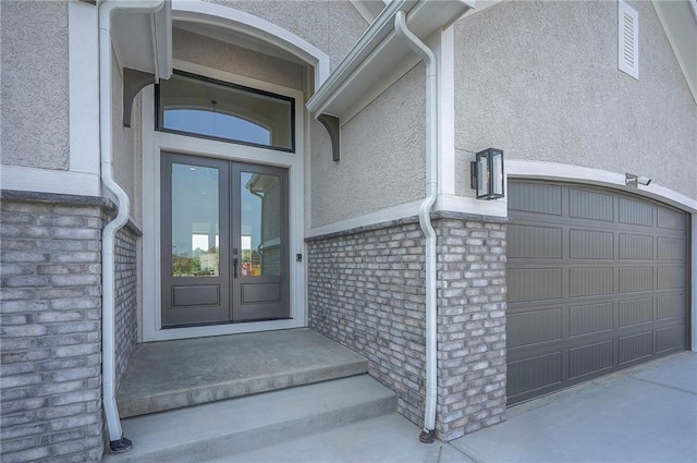 9000 N Clarion Ave, Kansas City, MO 64153 - doorway to property featuring french doors, stucco siding, and a garage
