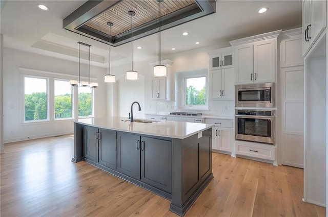 9000 N Clarion Ave, Kansas City, MO 64153 - kitchen with stainless steel appliances, a sink, white cabinetry, light countertops, and light wood-type flooring