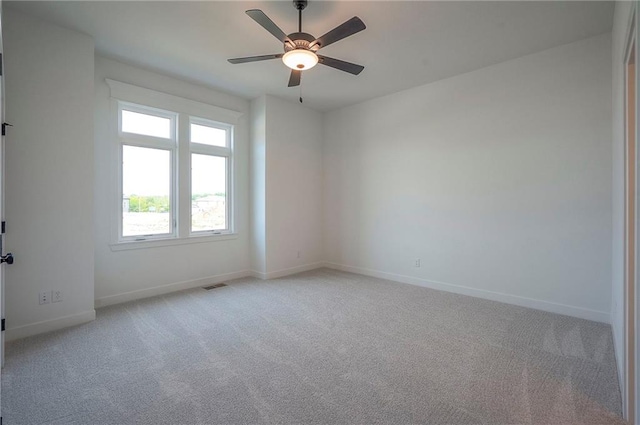 9000 N Clarion Ave, Kansas City, MO 64153 - spare room featuring light carpet, baseboards, and ceiling fan