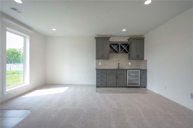9000 N Clarion Ave, Kansas City, MO 64153 - indoor wet bar with beverage cooler, light colored carpet, recessed lighting, decorative backsplash, and baseboards