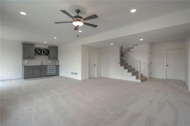 9000 N Clarion Ave, Kansas City, MO 64153 - unfurnished living room with bar with sink, wine cooler, recessed lighting, stairs, and light carpet