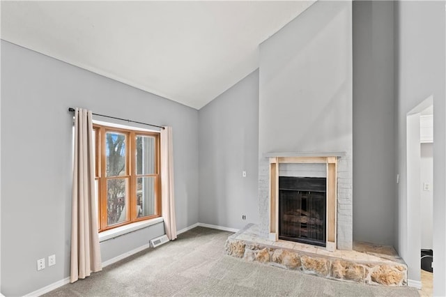 unfurnished living room with visible vents, a fireplace with raised hearth, baseboards, lofted ceiling, and carpet