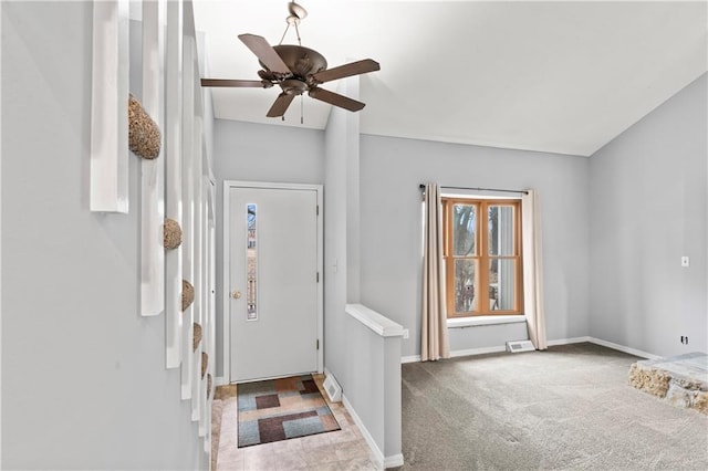 entryway with carpet floors, visible vents, baseboards, and a ceiling fan